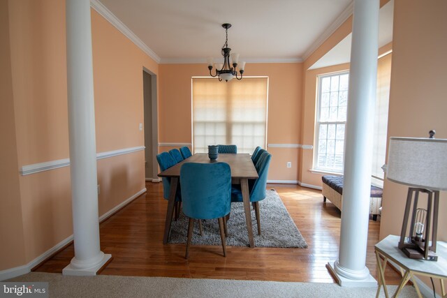12253 Tulane Falls Dr, Bristow, VA 20136 - dining area featuring crown molding, wood finished floors, baseboards, a notable chandelier, and ornate columns