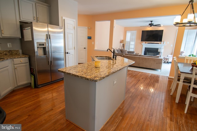 12253 Tulane Falls Dr, Bristow, VA 20136 - kitchen featuring ceiling fan with notable chandelier, hardwood / wood-style floors, a sink, and stainless steel fridge