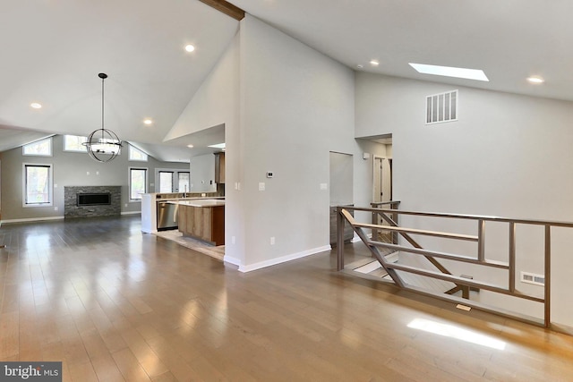 interior space featuring high vaulted ceiling, baseboards, and visible vents
