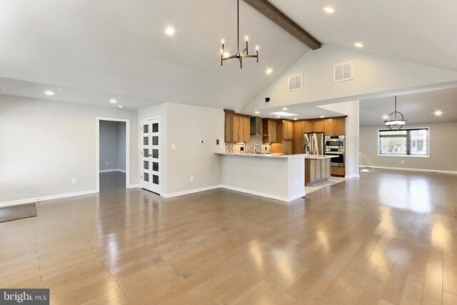 unfurnished living room with visible vents, baseboards, beam ceiling, and a chandelier