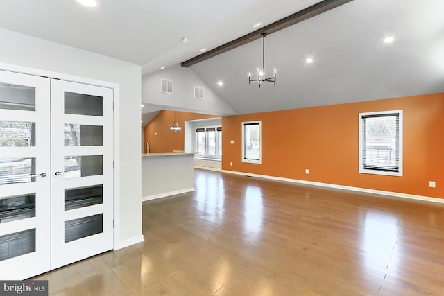 interior space featuring a notable chandelier, baseboards, beamed ceiling, and wood finished floors