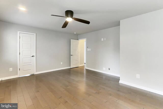 spare room with wood finished floors, ceiling fan, and baseboards