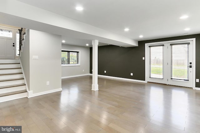 unfurnished living room with baseboards, recessed lighting, wood finished floors, and stairs