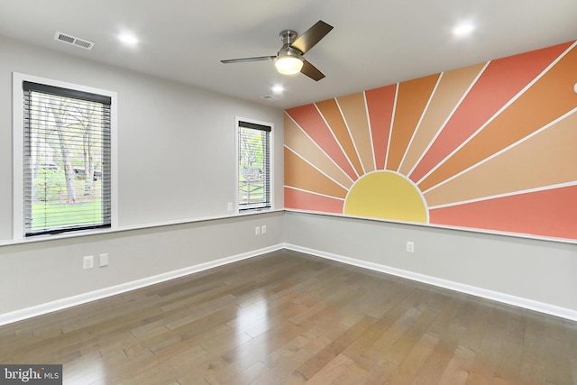 spare room with hardwood / wood-style floors, ceiling fan, baseboards, and visible vents