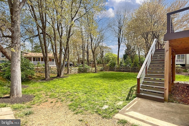 view of yard featuring fence and stairs