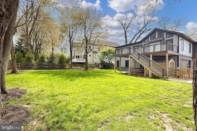 view of yard with a wooden deck, fence, a patio area, and stairs