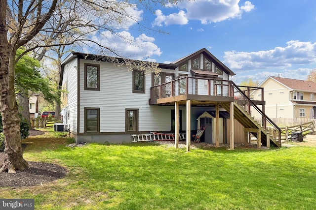 rear view of house featuring a deck, a yard, fence, cooling unit, and stairs