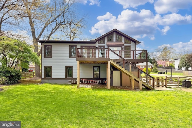 back of property with stairs, a yard, a wooden deck, and fence