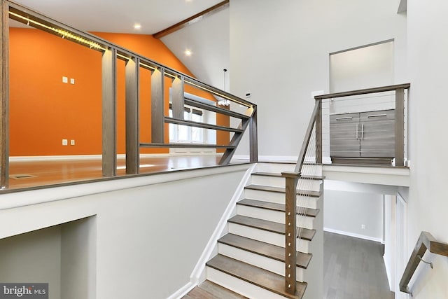 stairs with baseboards, recessed lighting, wood finished floors, and lofted ceiling