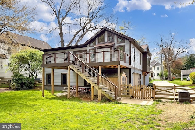 rear view of property featuring a yard, a wooden deck, and stairs