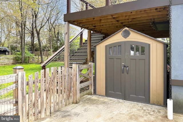 view of shed with stairway and fence