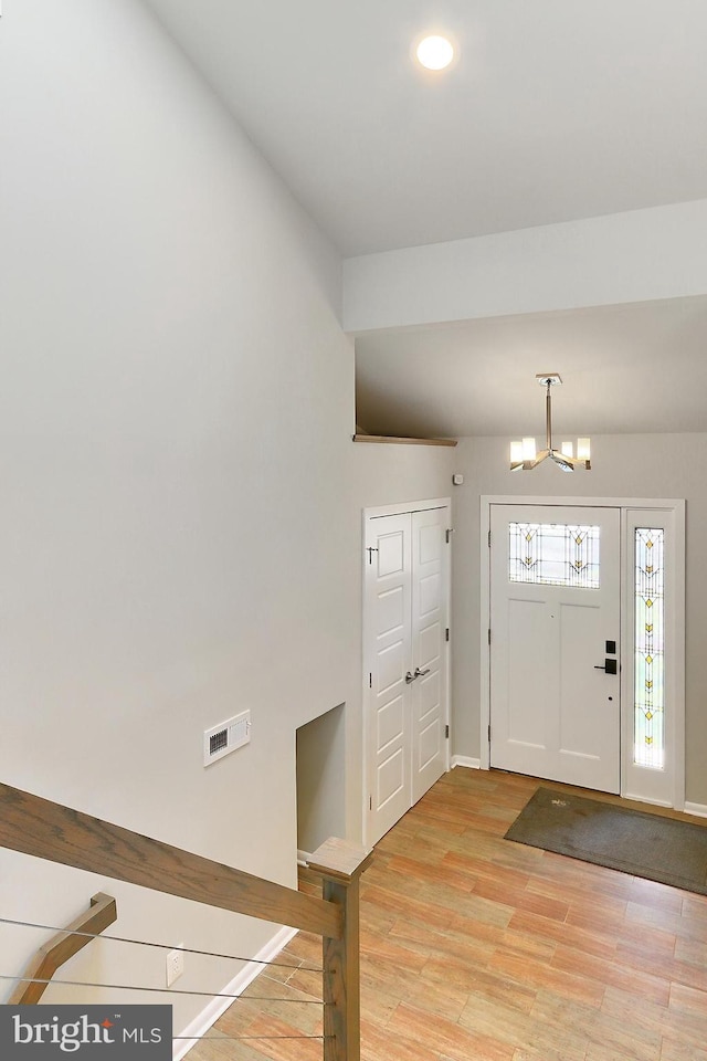entryway featuring baseboards, a chandelier, recessed lighting, light wood-style floors, and visible vents