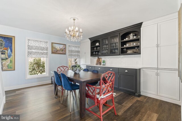 dining space with an inviting chandelier, baseboards, ornamental molding, and dark wood-style flooring