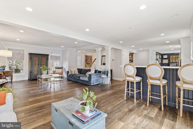 living room with recessed lighting, baseboards, ornamental molding, and wood finished floors