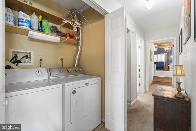 clothes washing area featuring laundry area, separate washer and dryer, baseboards, and light carpet