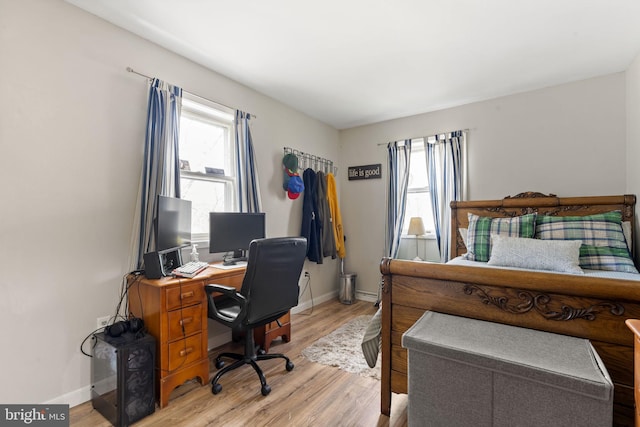 bedroom with light wood-style flooring and baseboards