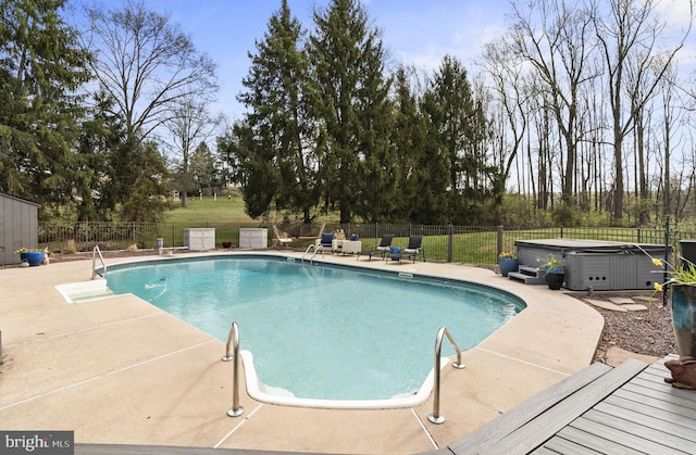 view of swimming pool featuring a fenced backyard, a fenced in pool, a patio, and a hot tub