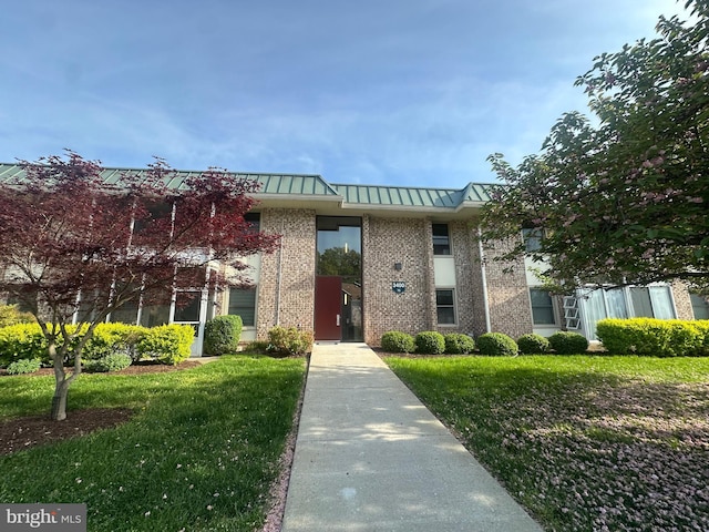 3400 Gleneagles Dr Unit 73-3E, Silver Spring, MD 20906 - view of front facade featuring brick siding, a front lawn, a standing seam roof, and metal roof