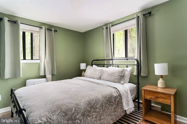 bedroom with baseboards and multiple windows