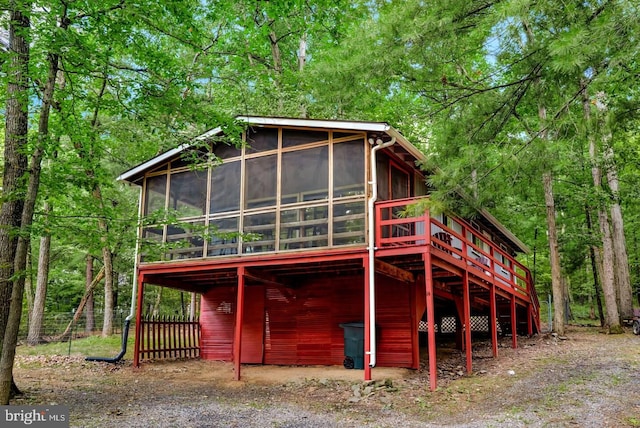 exterior space with a sunroom, a carport, and a deck