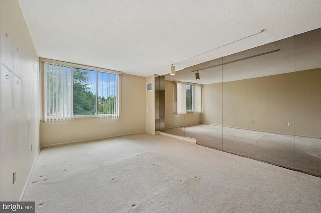 carpeted empty room featuring plenty of natural light and baseboards