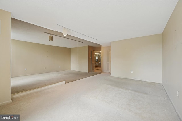 unfurnished room with light carpet and baseboards