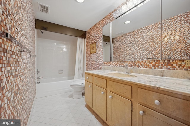 bathroom with tile patterned floors, toilet, shower / bathtub combination with curtain, tile walls, and vanity