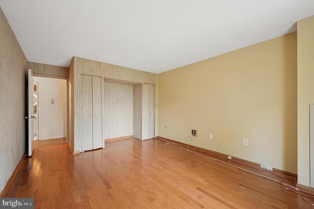 unfurnished bedroom with wood finished floors and a closet