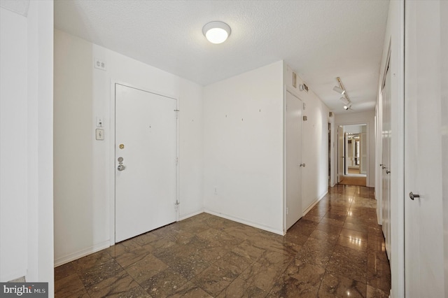 entryway with a textured ceiling and baseboards