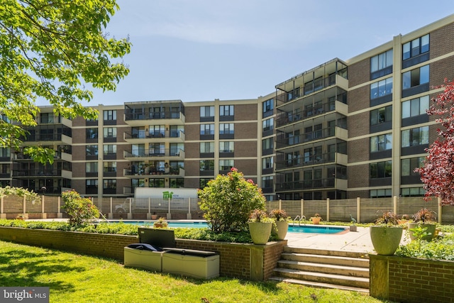 view of community featuring a swimming pool and fence