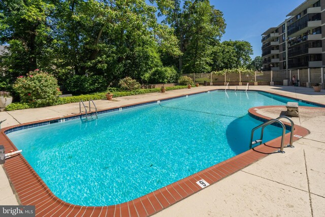 community pool featuring fence and a patio area