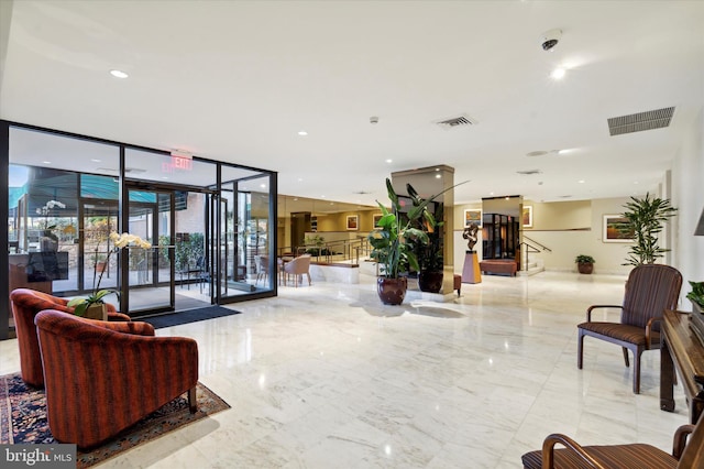 common area with a security system, a wall of windows, and stairs