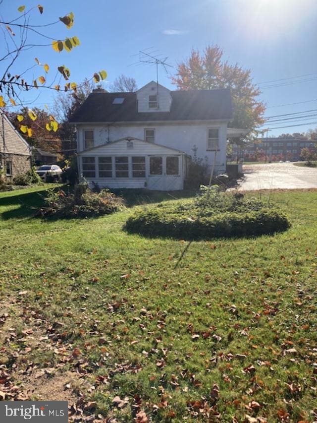 rear view of property featuring a lawn