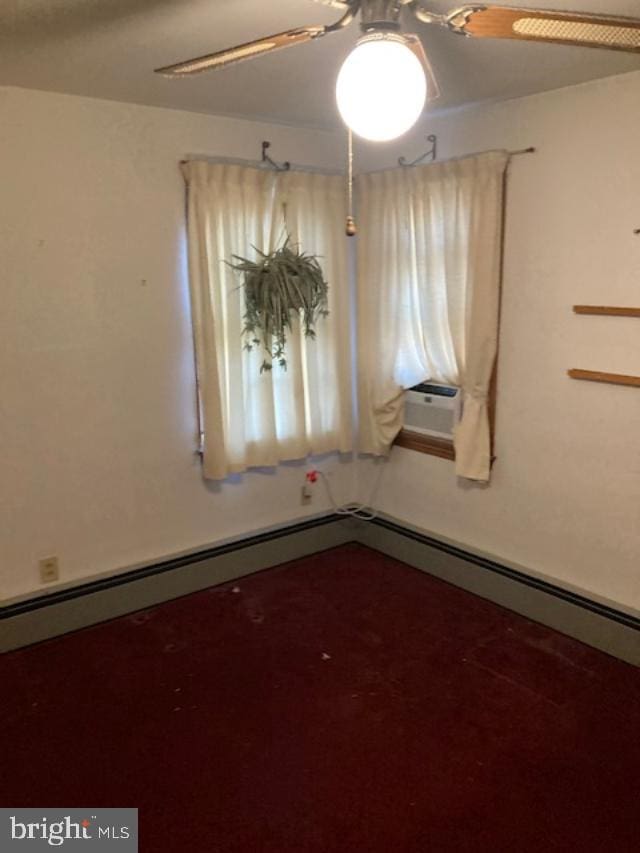 empty room featuring ceiling fan, dark colored carpet, and baseboards