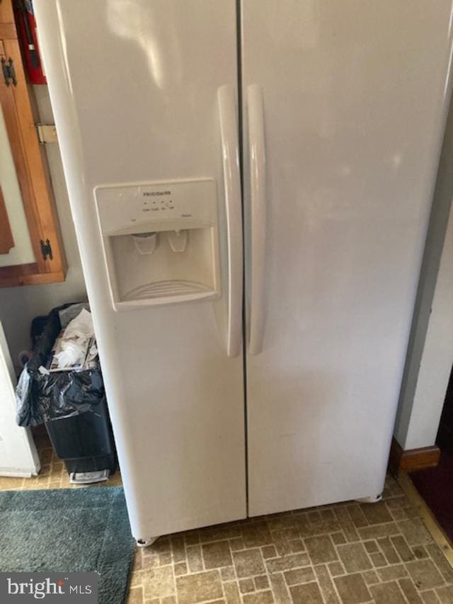 details with brown cabinets and white fridge with ice dispenser