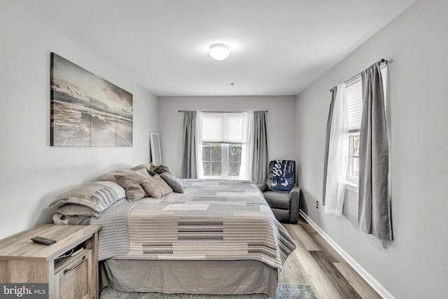 bedroom with baseboards and wood finished floors