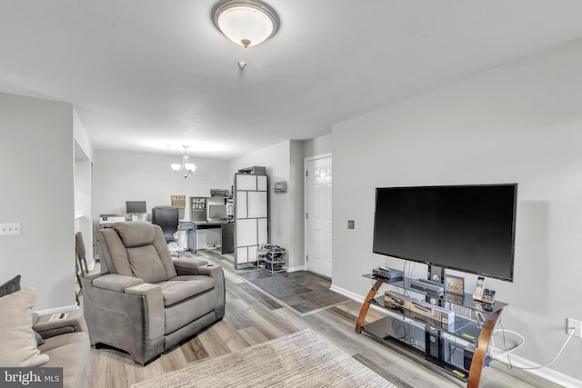 living room with baseboards, a chandelier, and wood finished floors