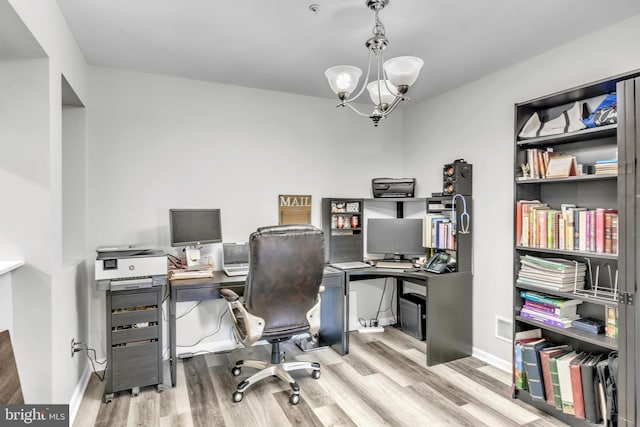 office space featuring baseboards, light wood-type flooring, and a notable chandelier