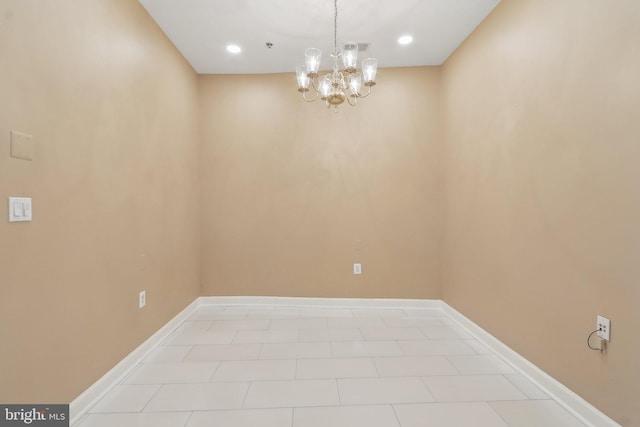 spare room with baseboards and a chandelier
