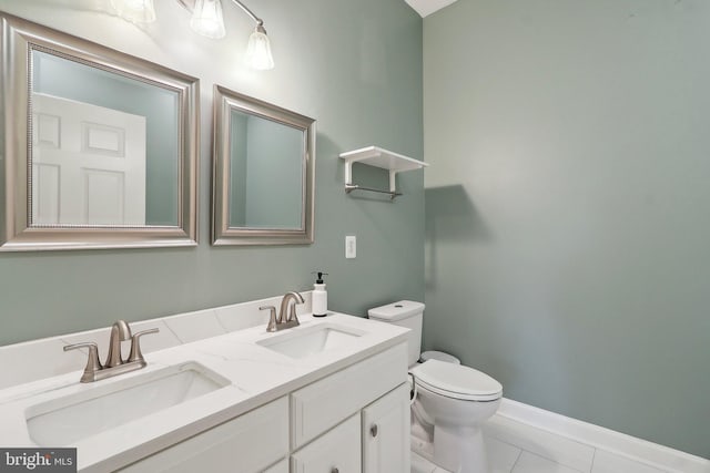 bathroom featuring tile patterned flooring, a sink, double vanity, and toilet