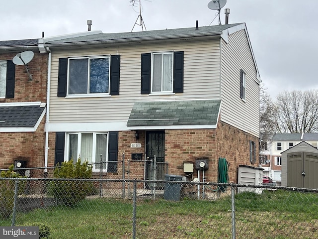 townhome / multi-family property featuring a fenced front yard and brick siding