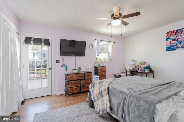bedroom featuring wood finished floors, a textured ceiling, and ceiling fan