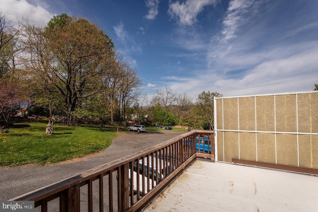 wooden terrace featuring a lawn