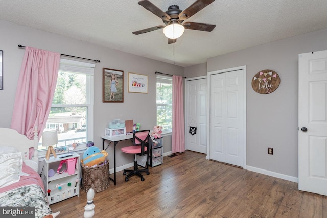 office area with ceiling fan, a wealth of natural light, wood finished floors, and baseboards