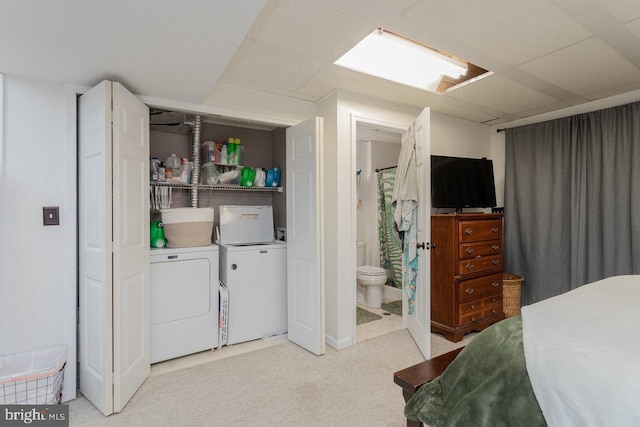 clothes washing area with light colored carpet, separate washer and dryer, and laundry area