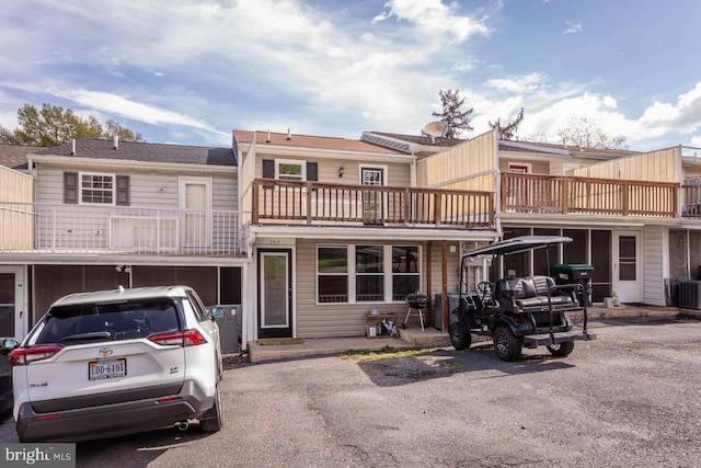back of house featuring central air condition unit and a balcony