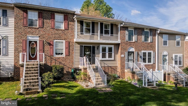 multi unit property featuring brick siding and a front yard