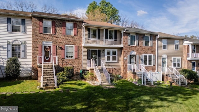 view of front of property featuring a front lawn and brick siding