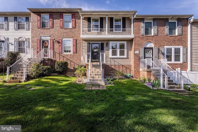 view of property with brick siding and a front lawn