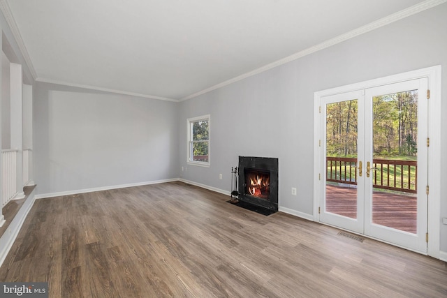 unfurnished living room with a fireplace with flush hearth, visible vents, baseboards, and wood finished floors
